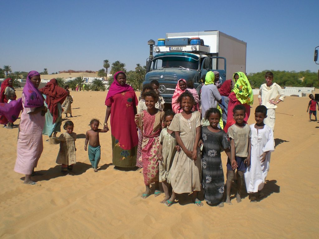 August der Reisewagen: August umringt von einer Familie im Sudan
