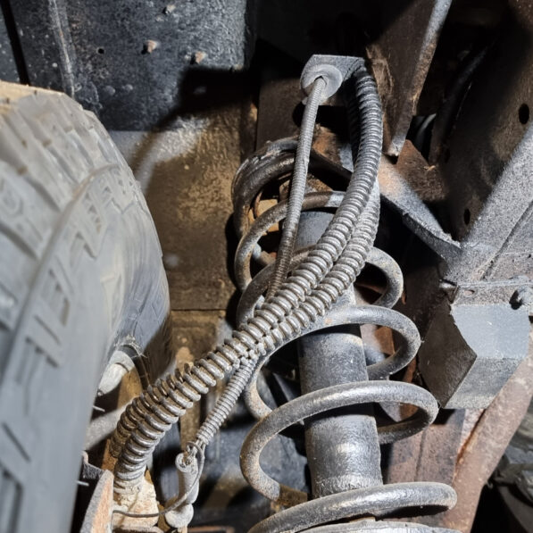 Flexible Bremsleitung an der Vorderachse zum gelenkten Rad.