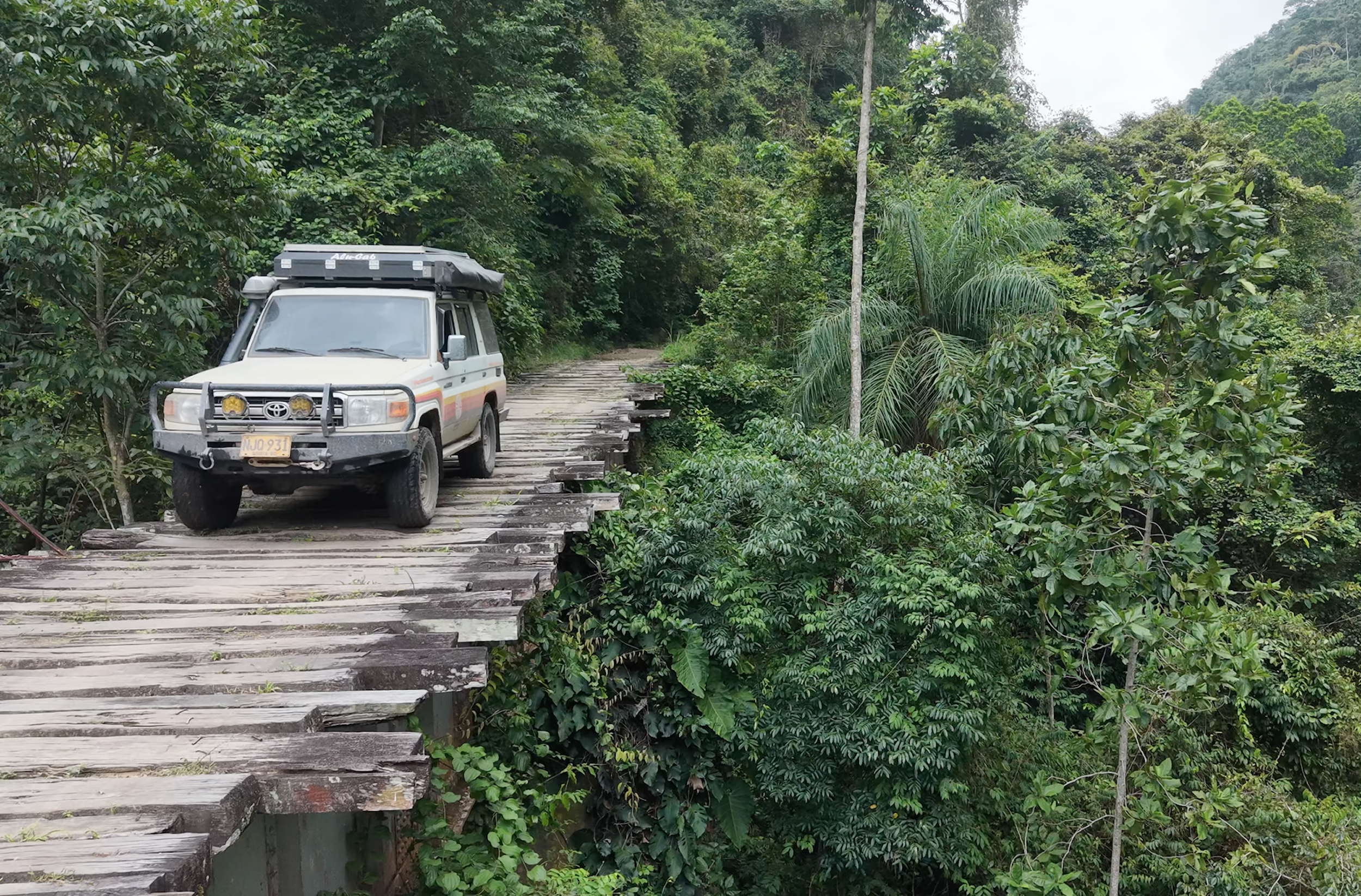 Land Cruiser auf einer alten Holzbrücke im Dschungel Kolumbiens