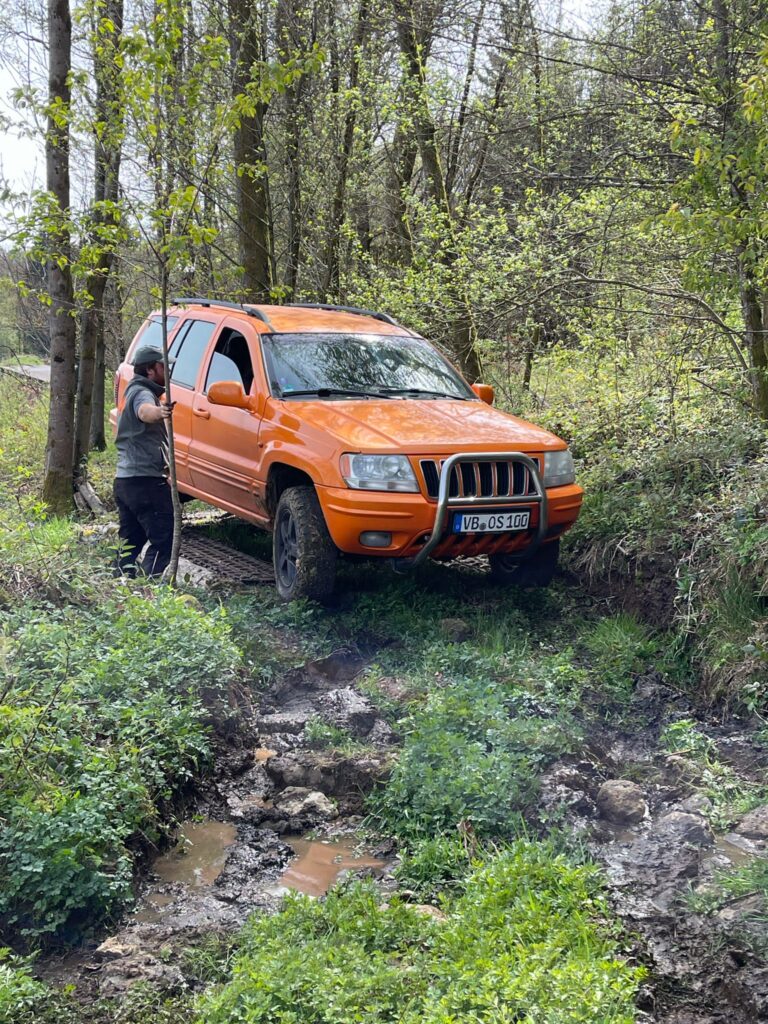 Orangefarbener Jeep Grand Cherokee in der Grabenpassage